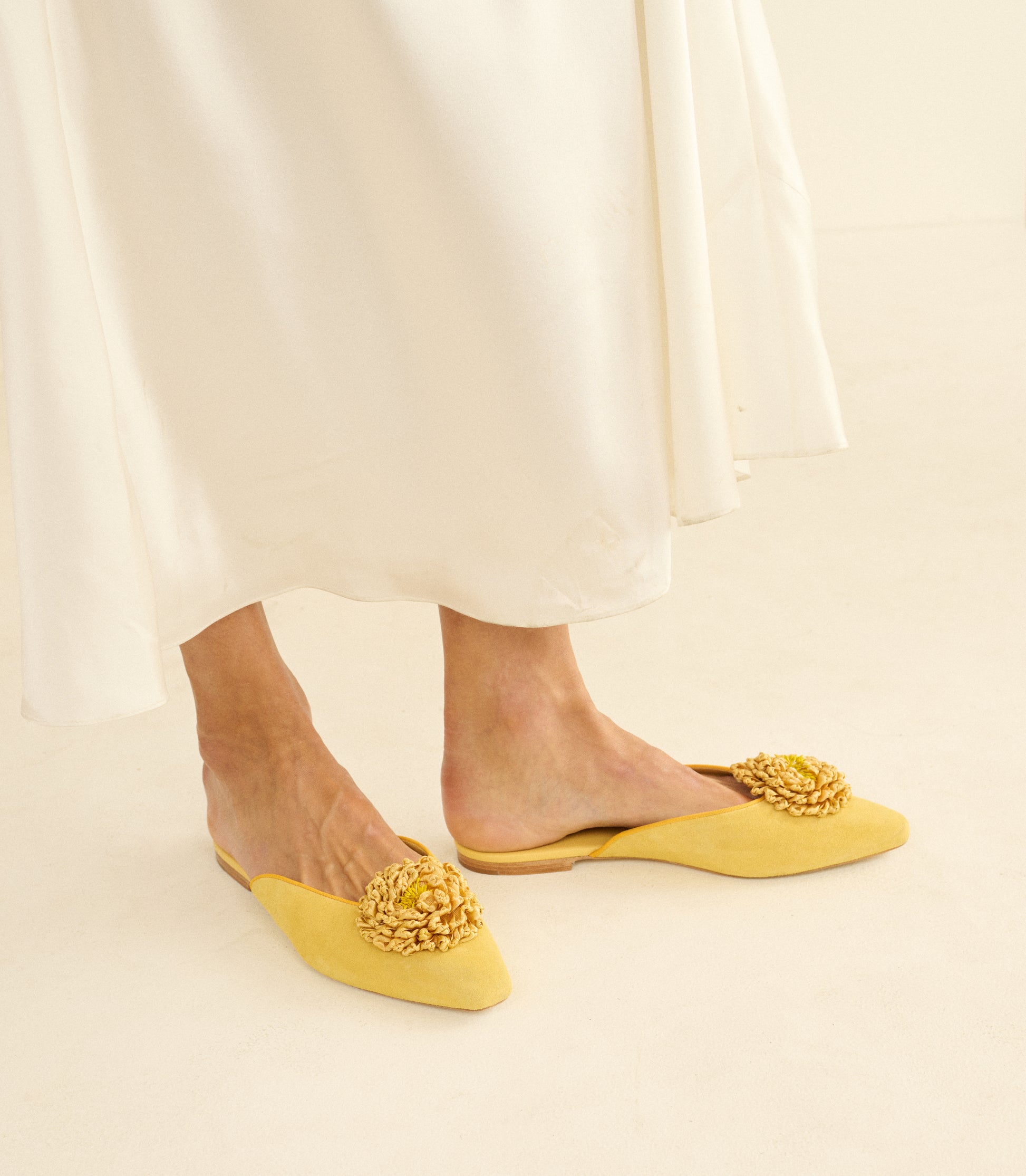 Yellow flats with floral details worn with a white skirt on a light background 1
