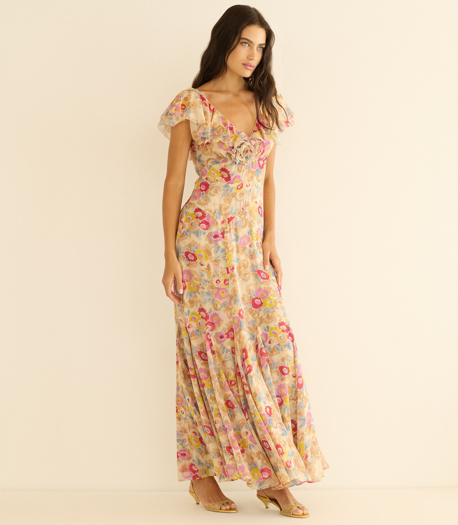 Woman wearing a long floral dress on a beige background 1
