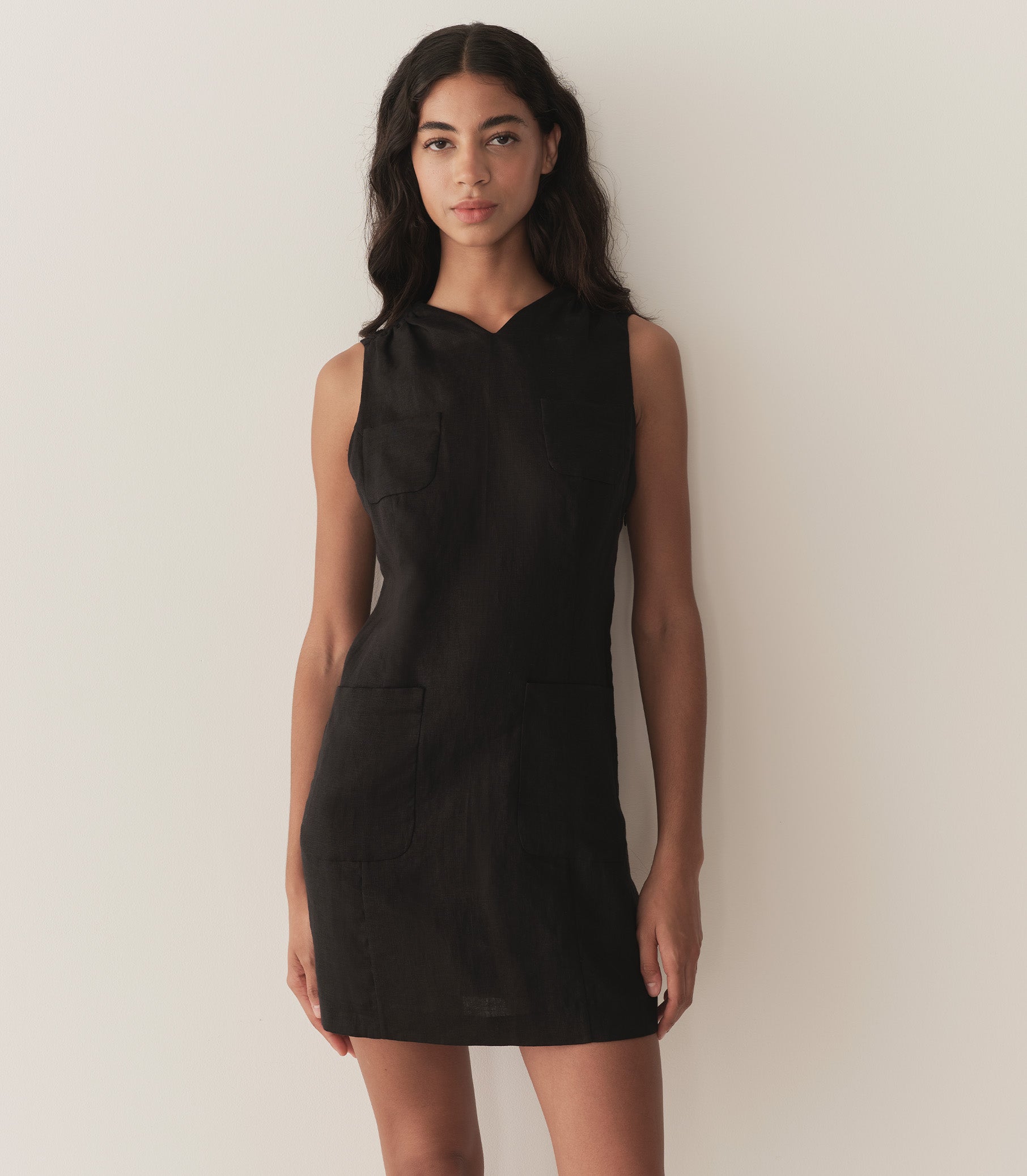 Rocio is wearing a black sleeveless linen mini dress. 1
