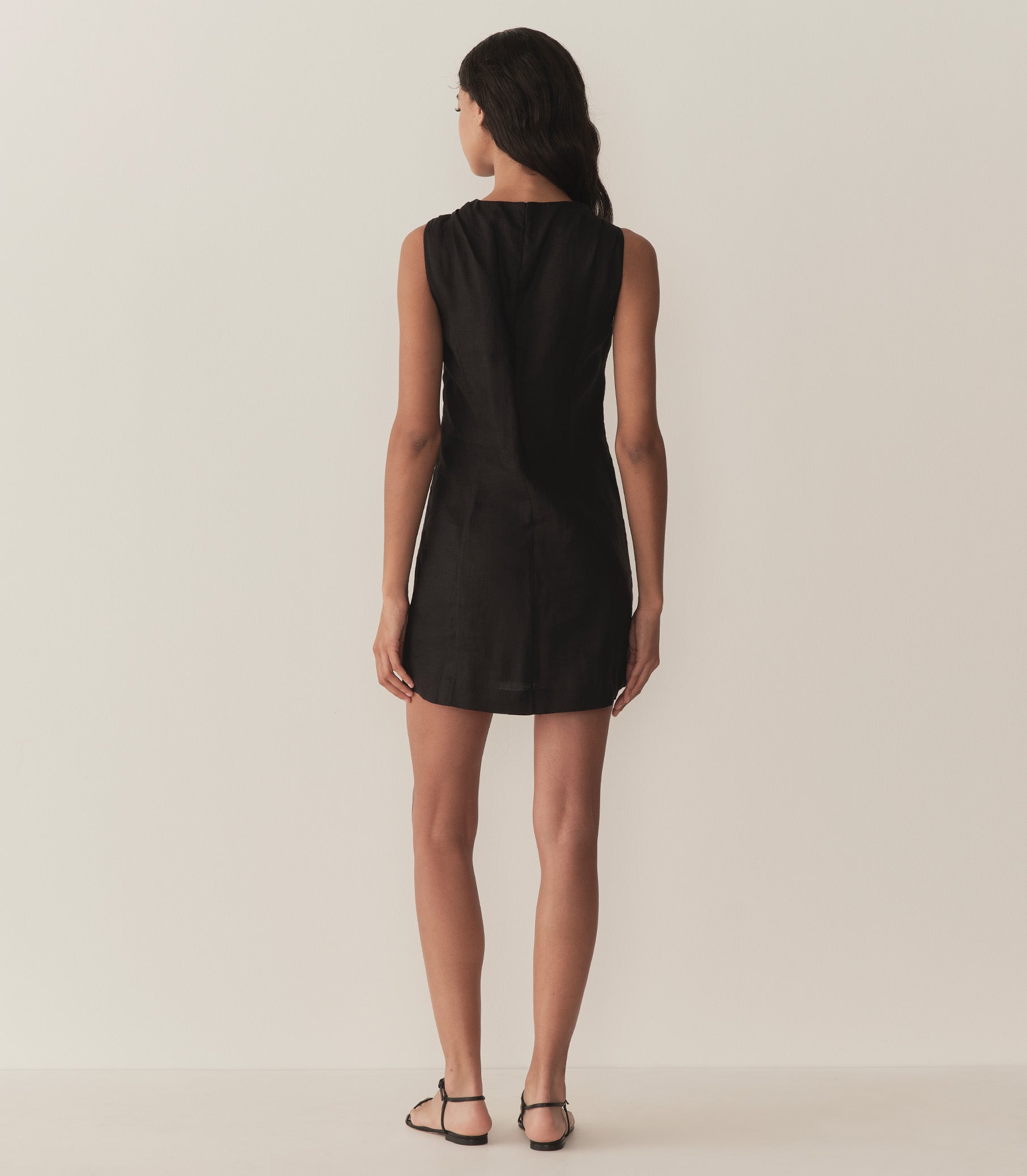 Rocio is wearing a black sleeveless linen mini dress. 4
