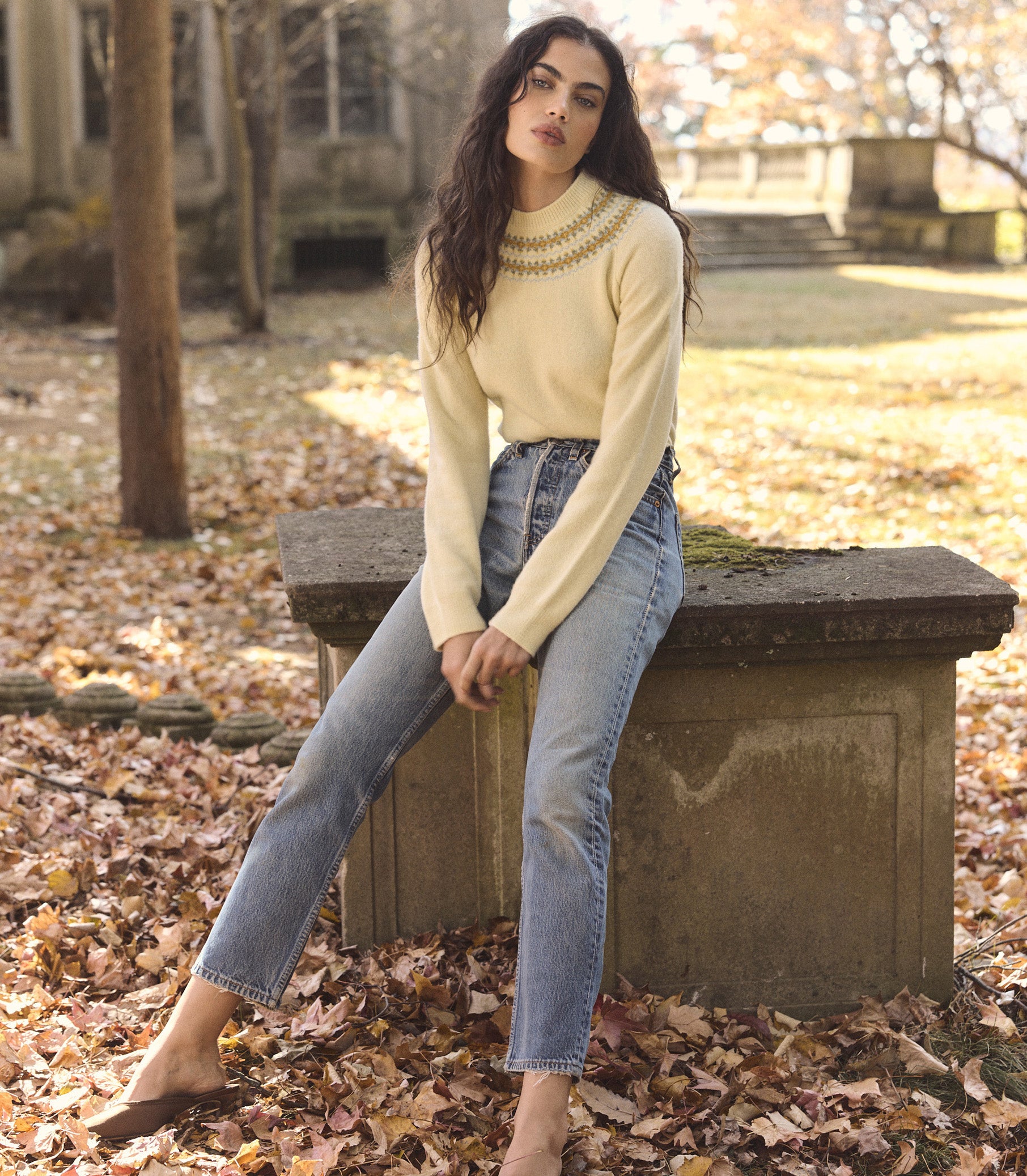 Woman is wearing a light yellow fair isle sweater with jeans. 1
