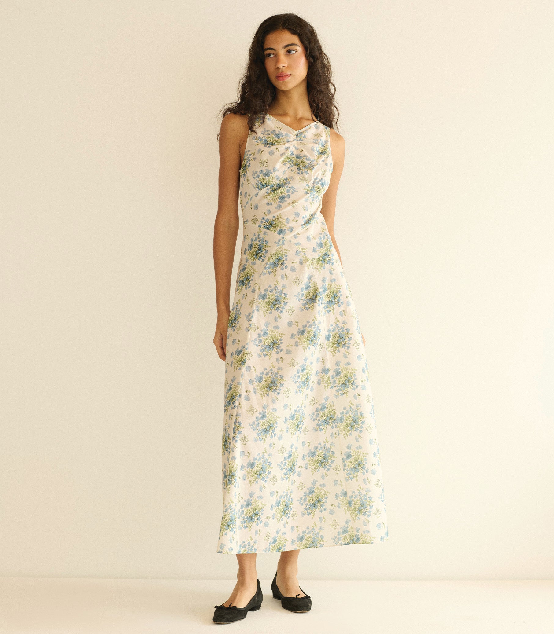 Woman wearing a floral dress against a plain background