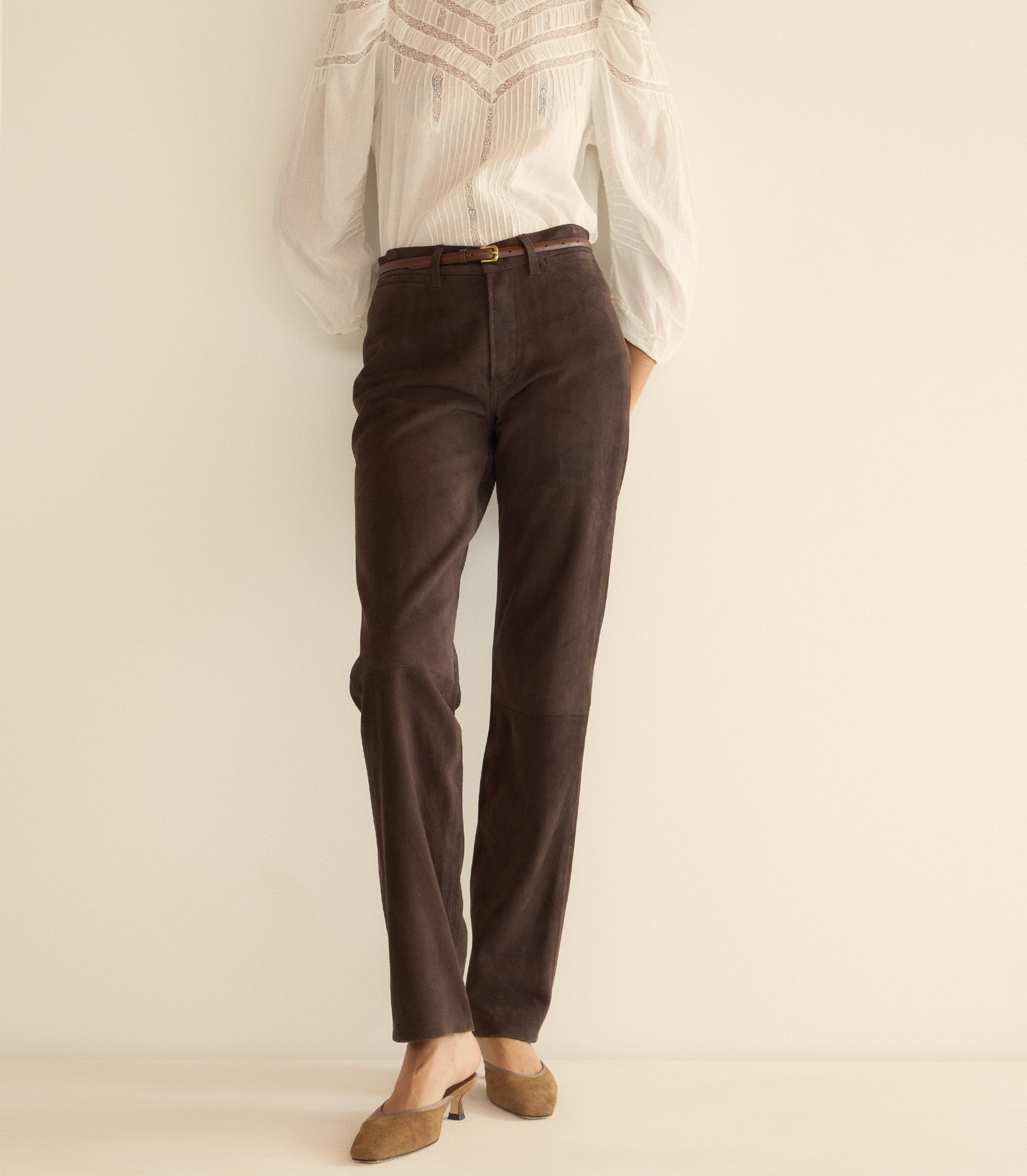 Brown pants worn with a white shirt on a plain background 1

