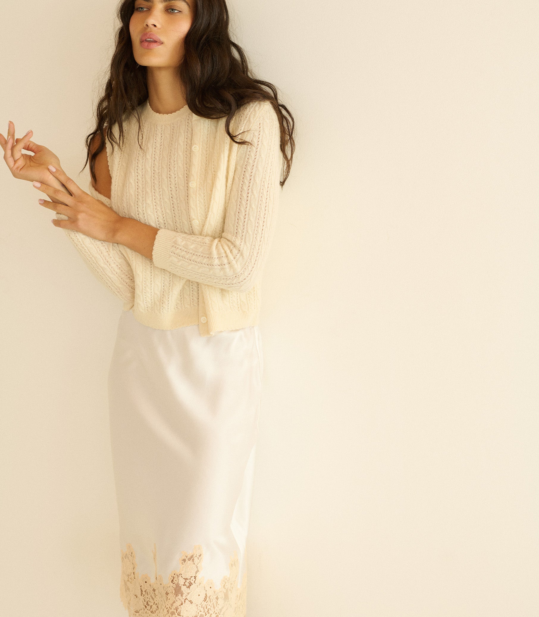Woman wearing a light-colored top and skirt against a plain background 4
