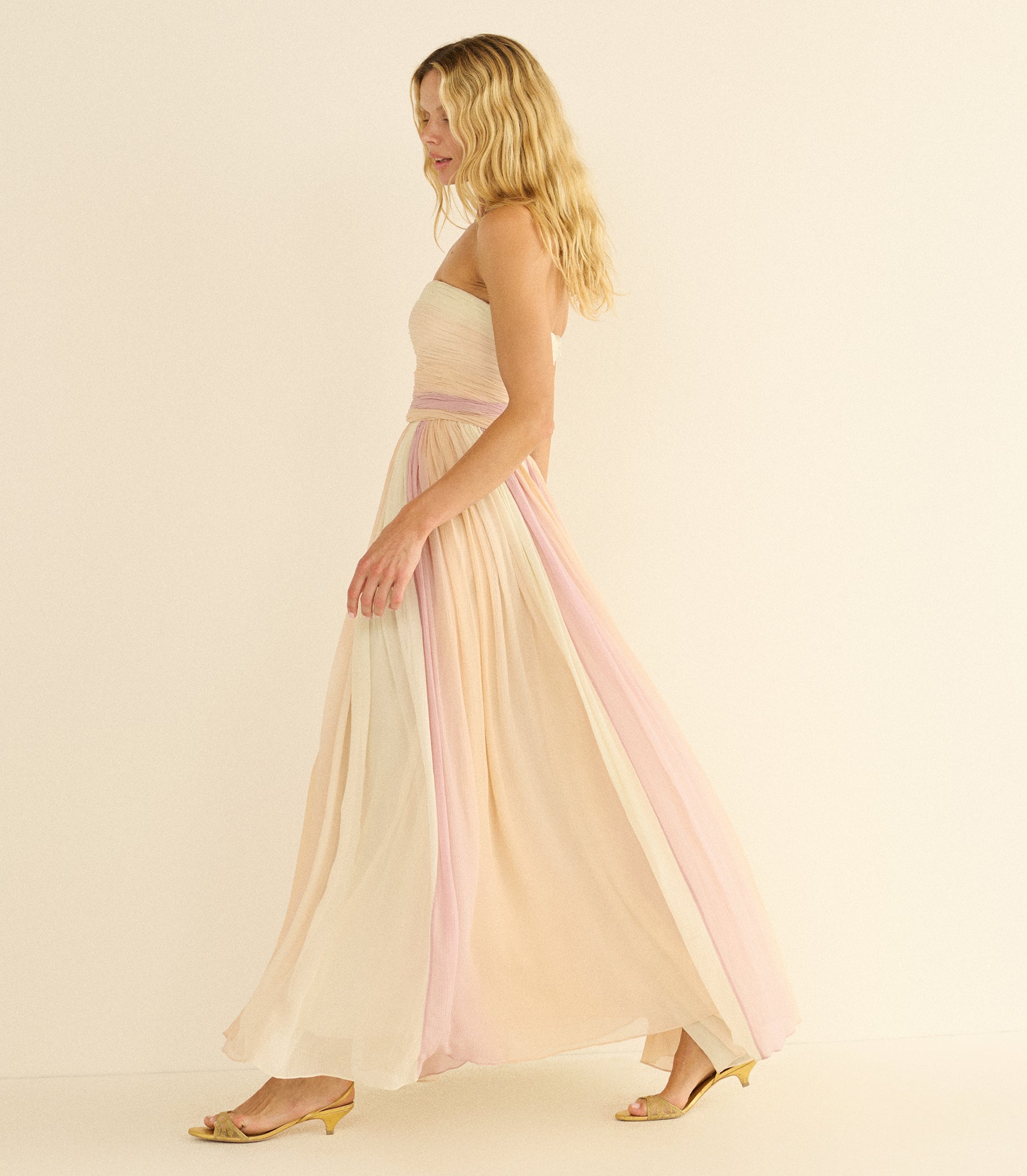 Woman wearing a strapless dress with pastel pink and beige gradient on a beige background 1
