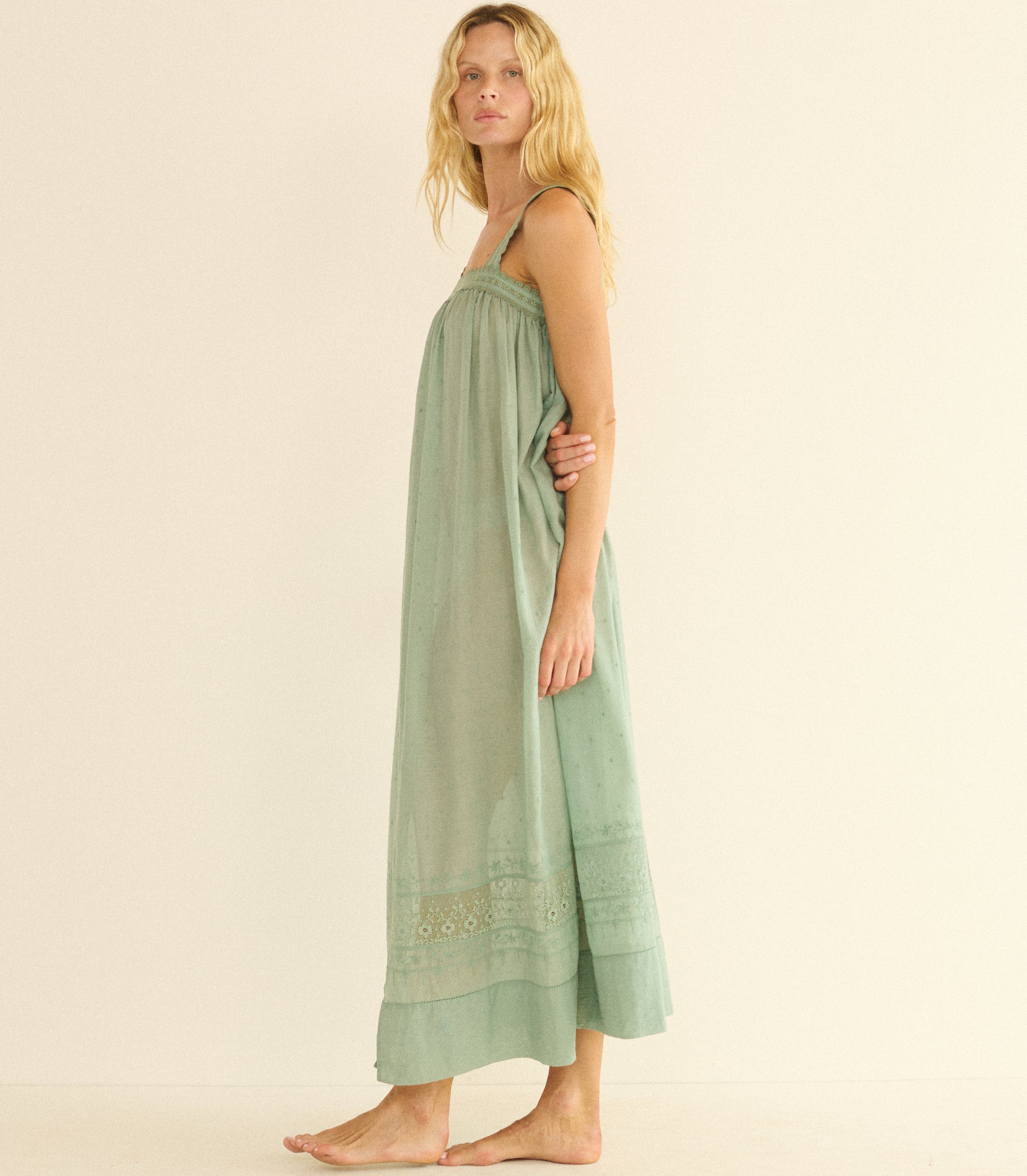 Woman wearing a green dress with embroidery on a beige background 1
