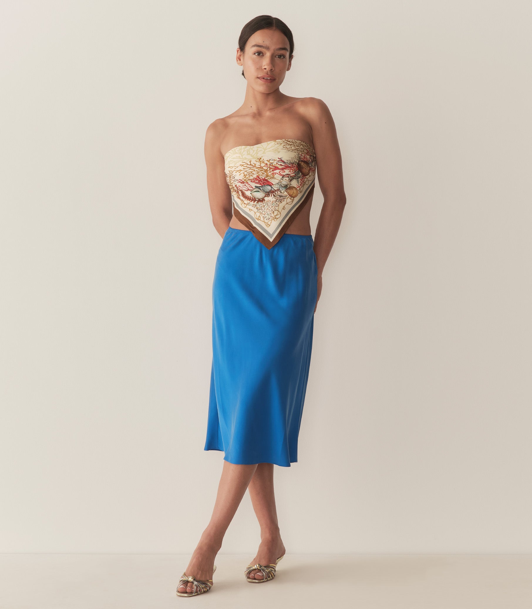 Zahara is wearing a blue midi skirt paired with a bandana top and metallic kitten heels. 4
