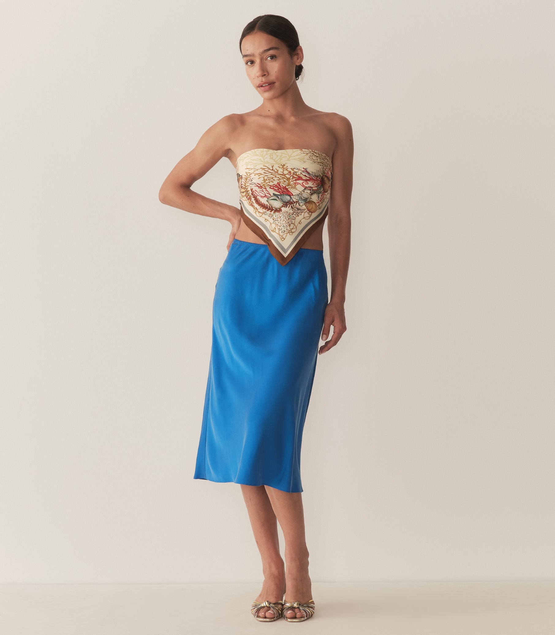 Zahara is wearing a blue midi skirt paired with a bandana top and metallic kitten heels. 3
