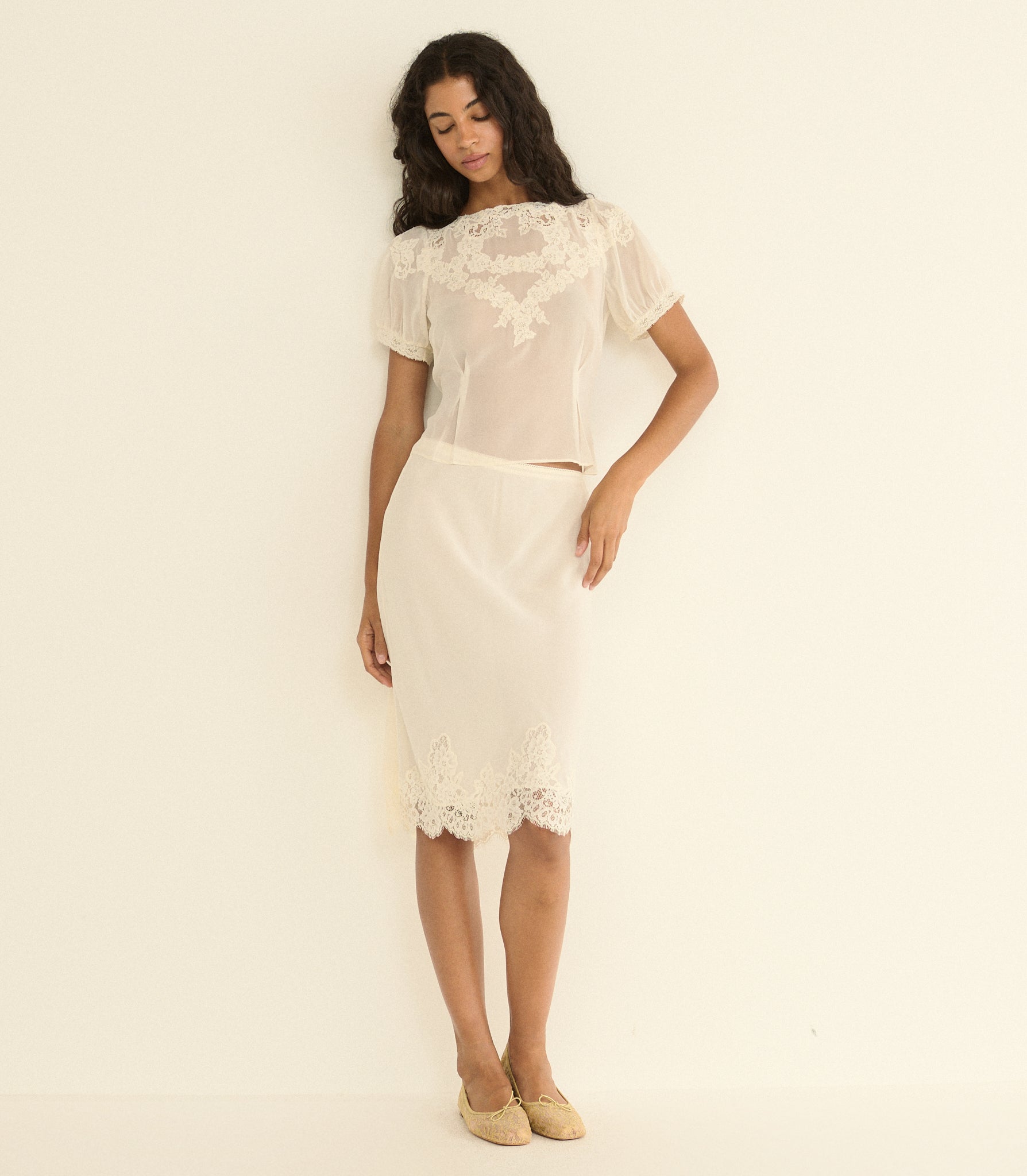 Woman wearing a white skirt outfit on a plain background