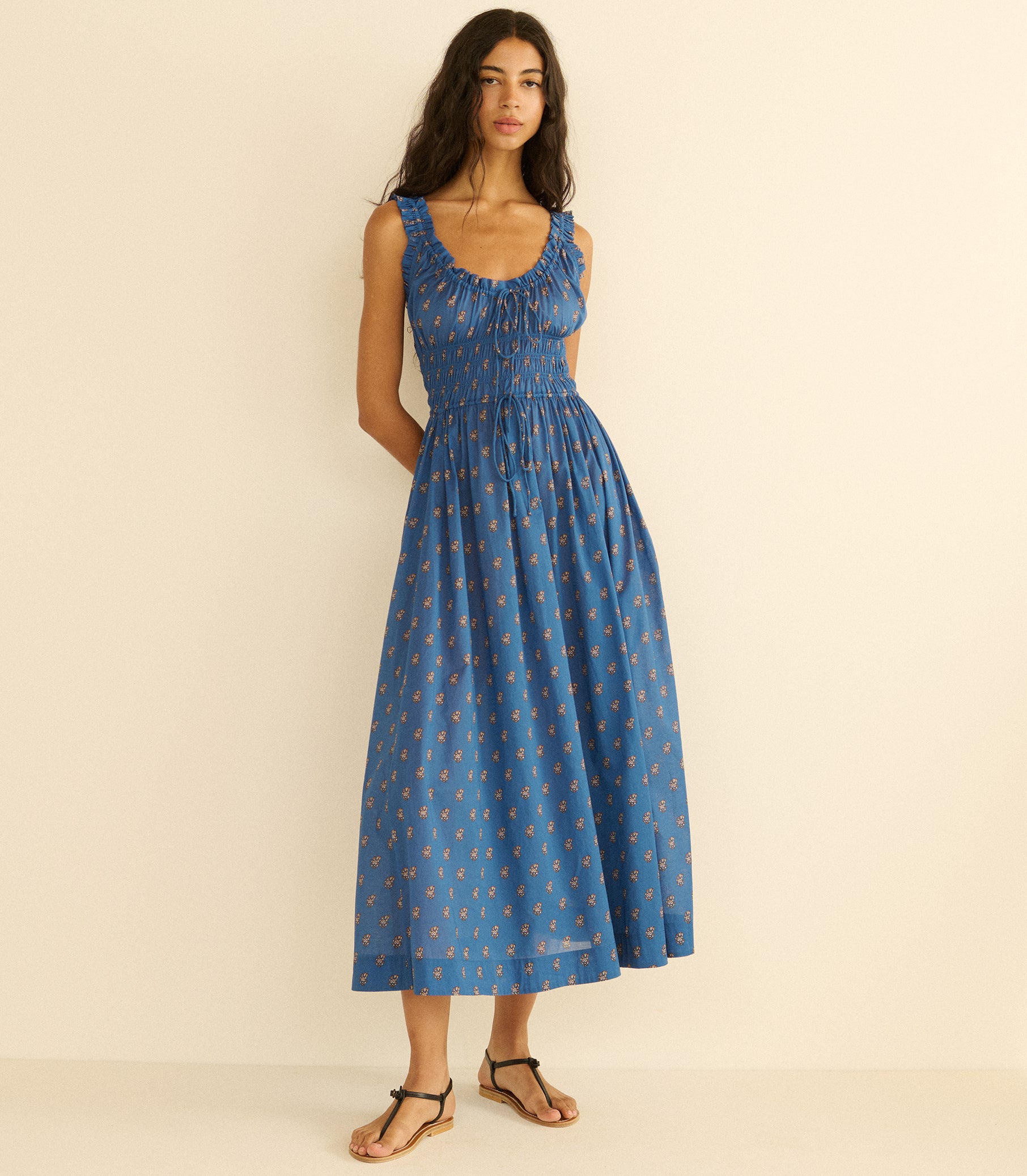 Woman wearing a blue paisley dress with a pattern on a beige background 2
