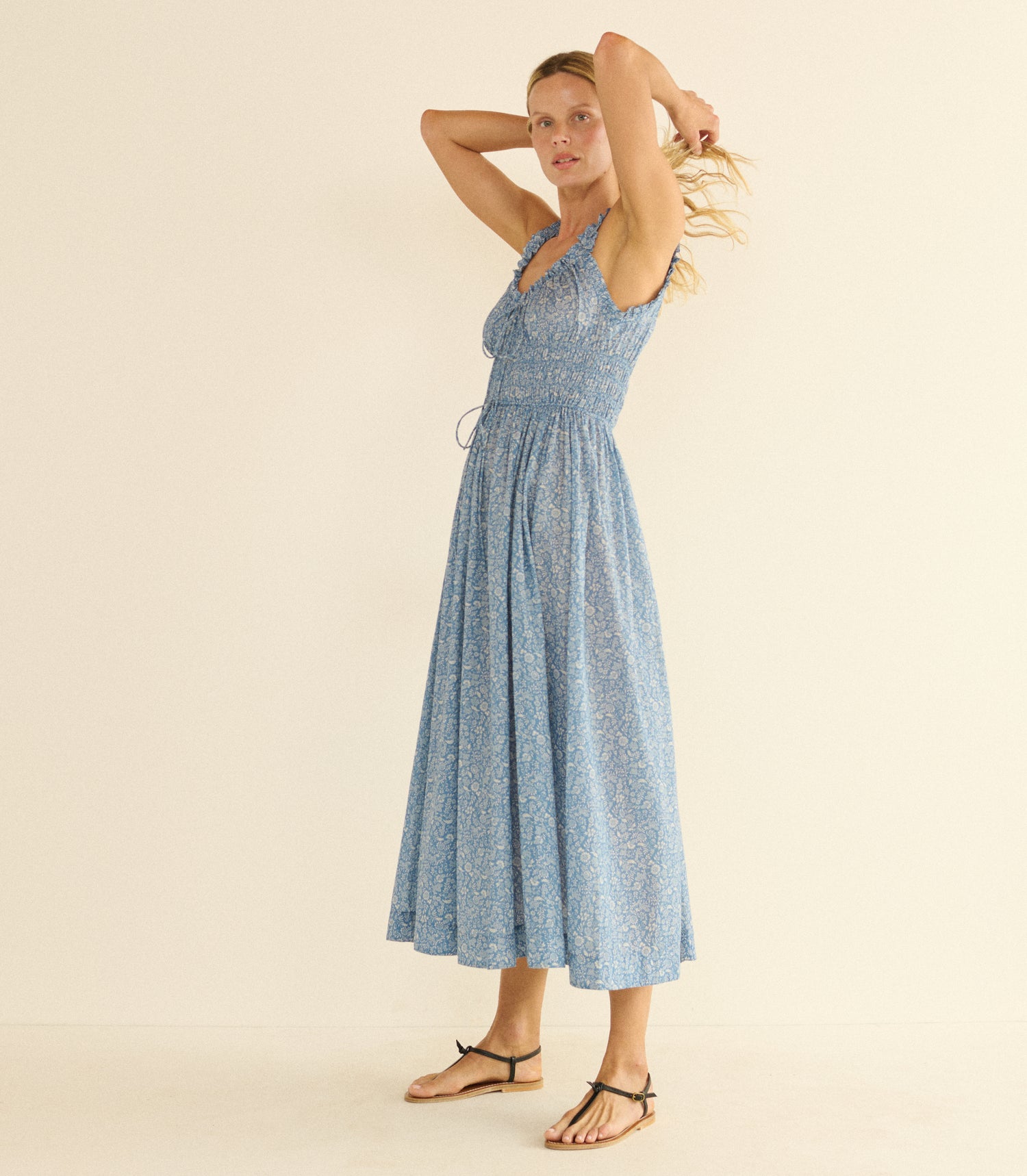 Woman wearing a blue dress against a beige background