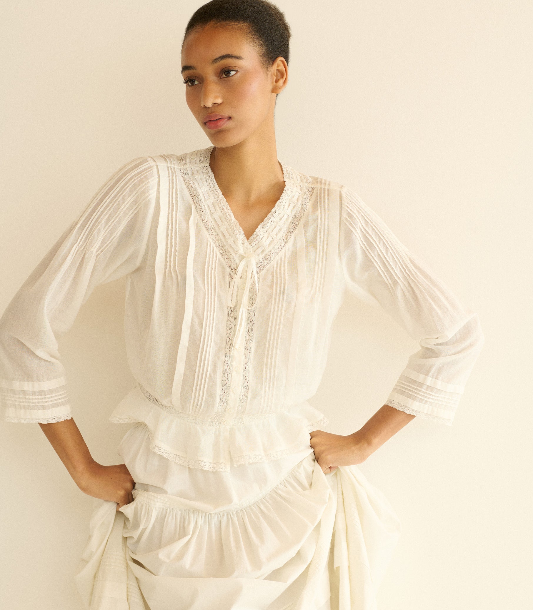 Woman wearing a white blouse with a plain background