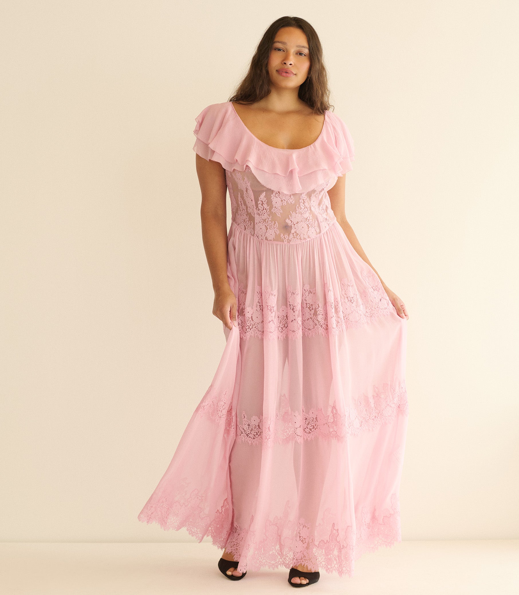 Woman wearing a pink dress with lace details on a beige background 1
