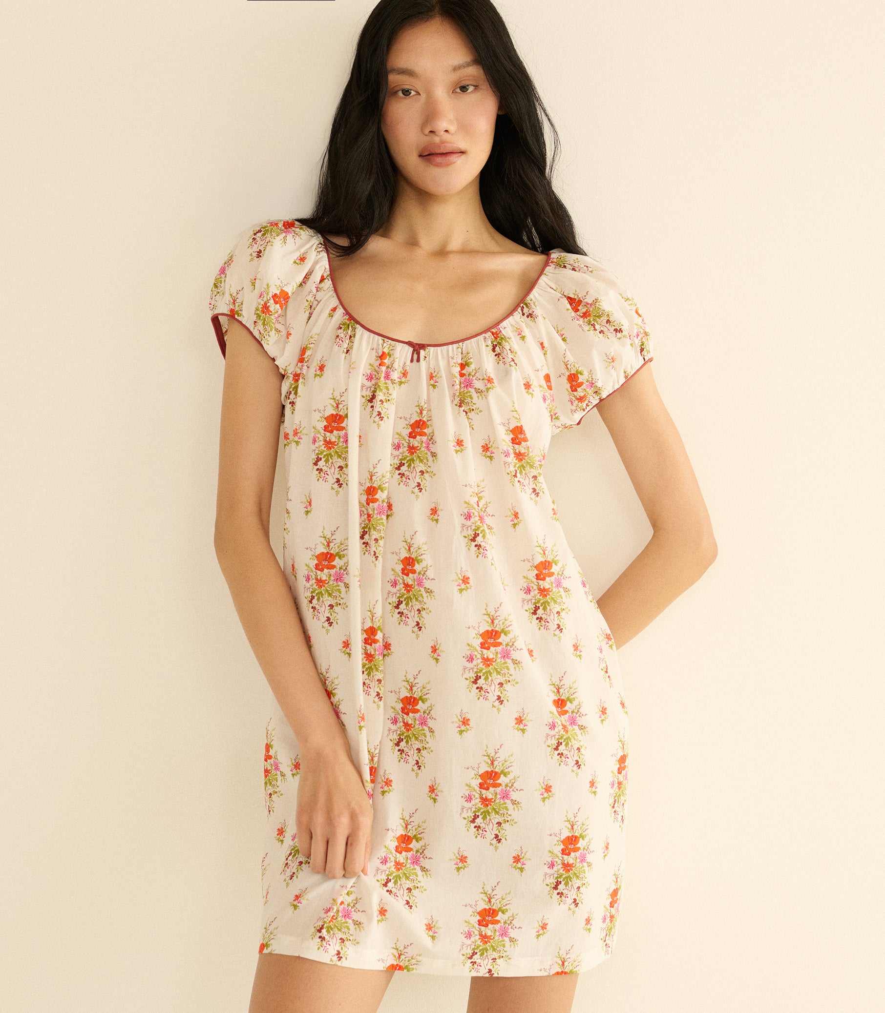 Woman wearing a floral dress against a plain background 2
