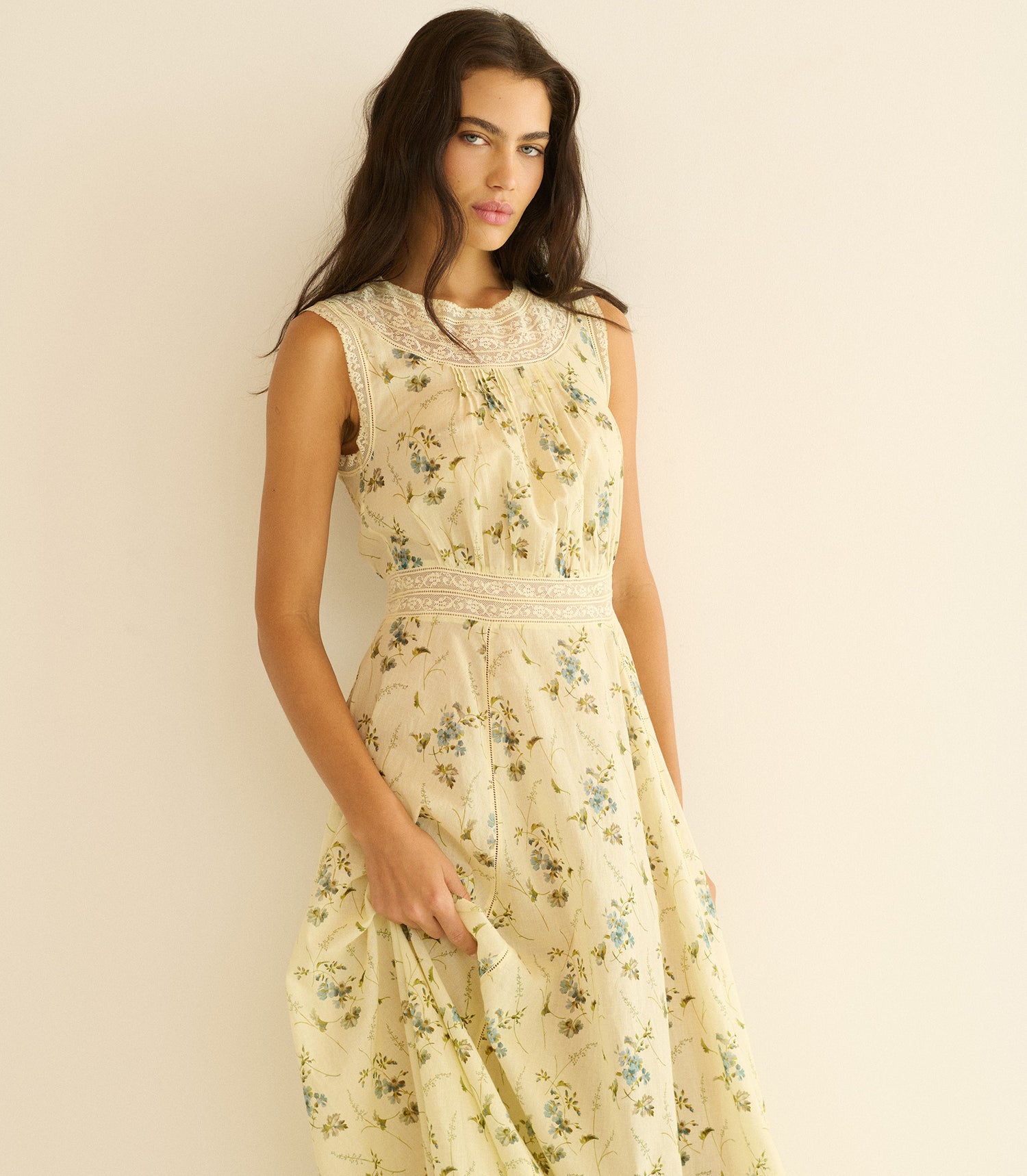 Woman wearing a floral dress against a plain background