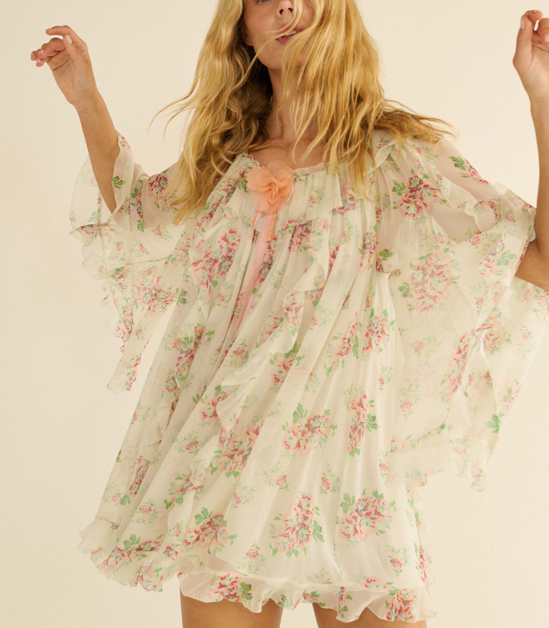 Woman wearing a white floral dress against a plain background 1
