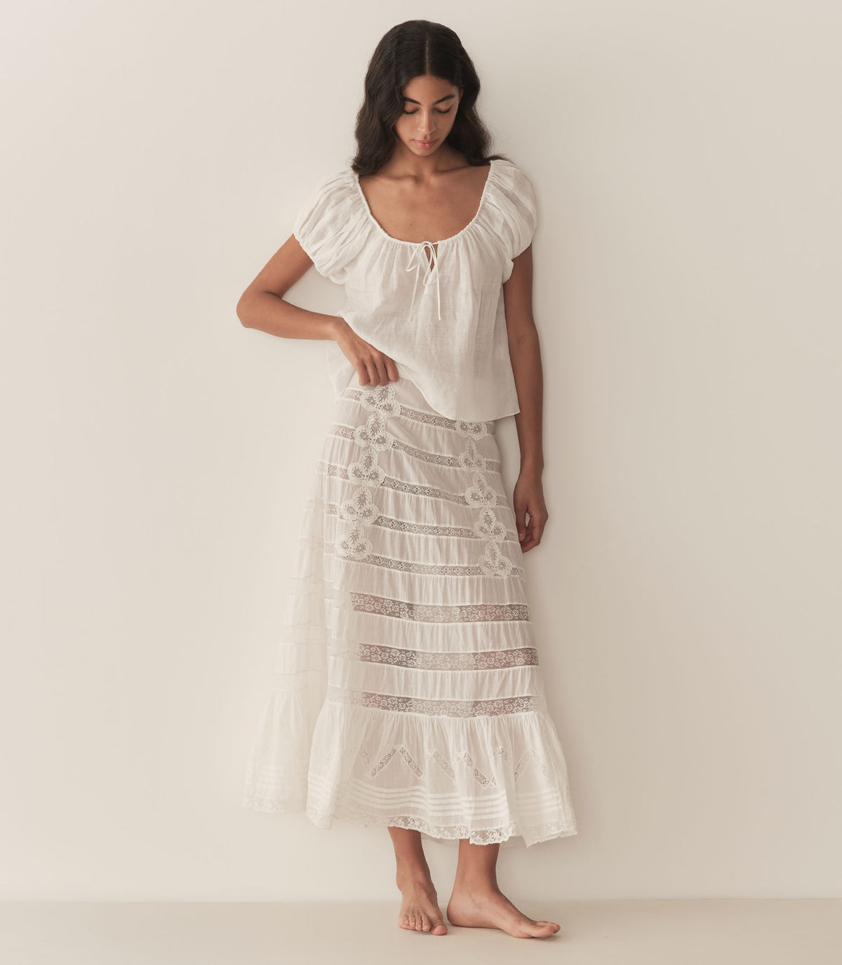 Rocio is wearing a white short puff sleeve blouse paired with a white maxi skirt. 3
