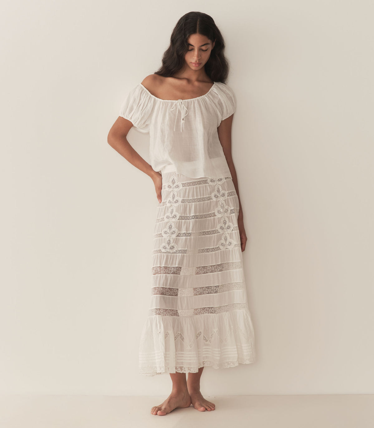 Rocio is wearing a white short puff sleeve blouse paired with a white maxi skirt. 1
