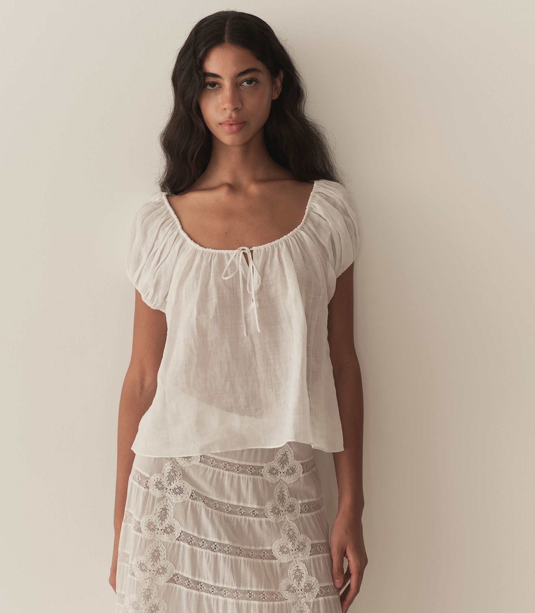 Rocio is wearing a white short puff sleeve blouse paired with a white maxi skirt. 2
