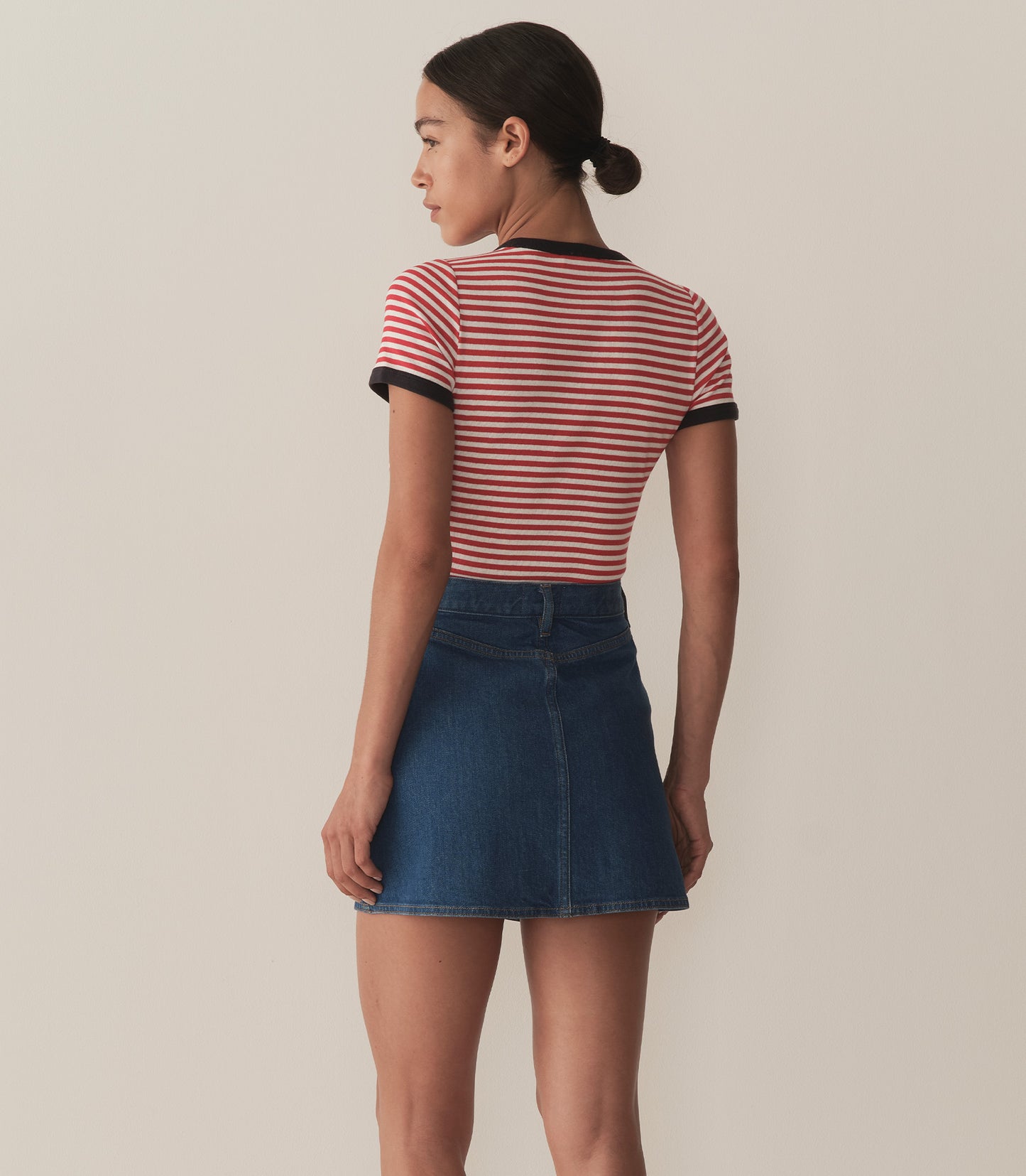 Zahara is wearing a denim A-Line skirt paired with a striped top.